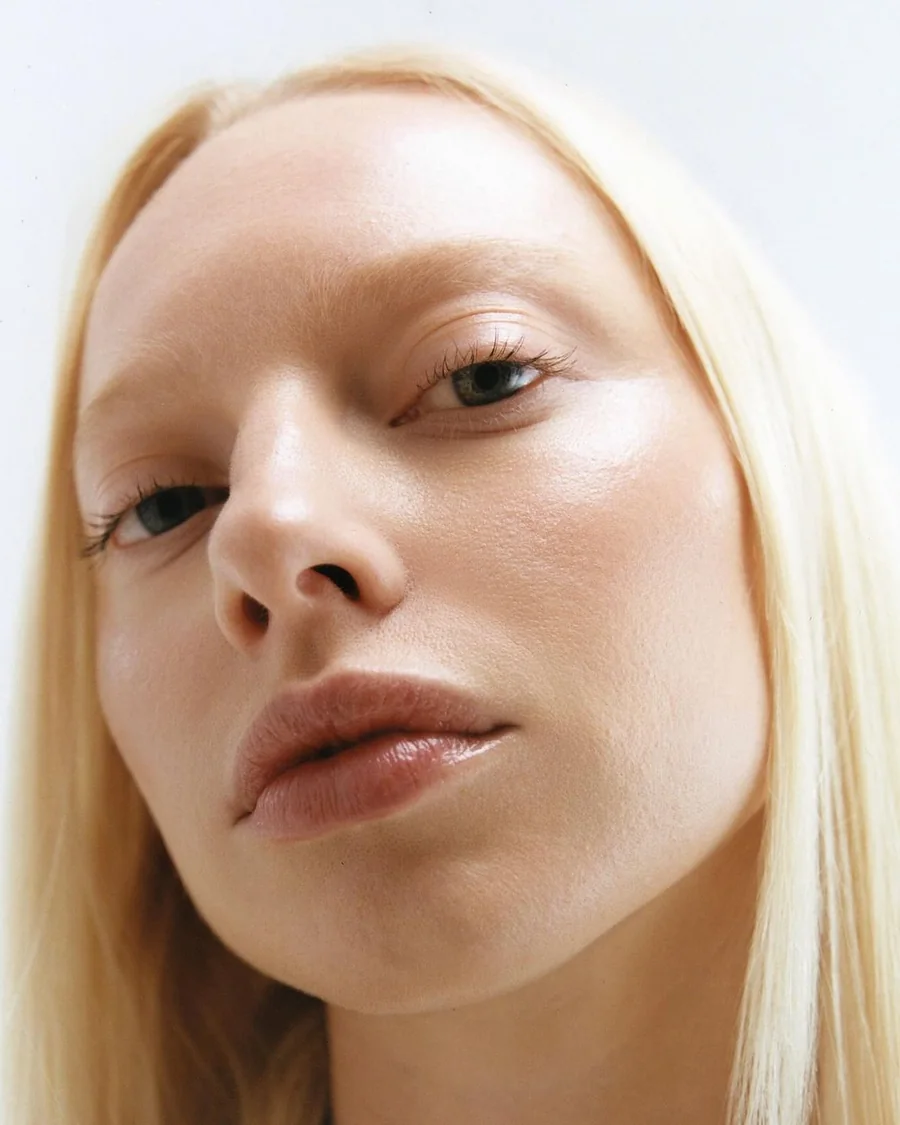 Close-up portrait of a blonde woman with dewy skin
